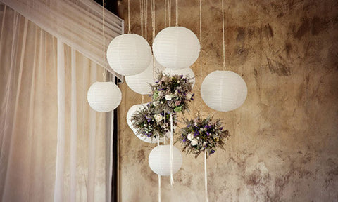 Round white paper lanterns mixed with flowers